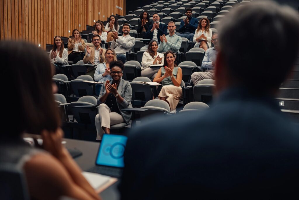 Business people applauding presentation at diversity conference