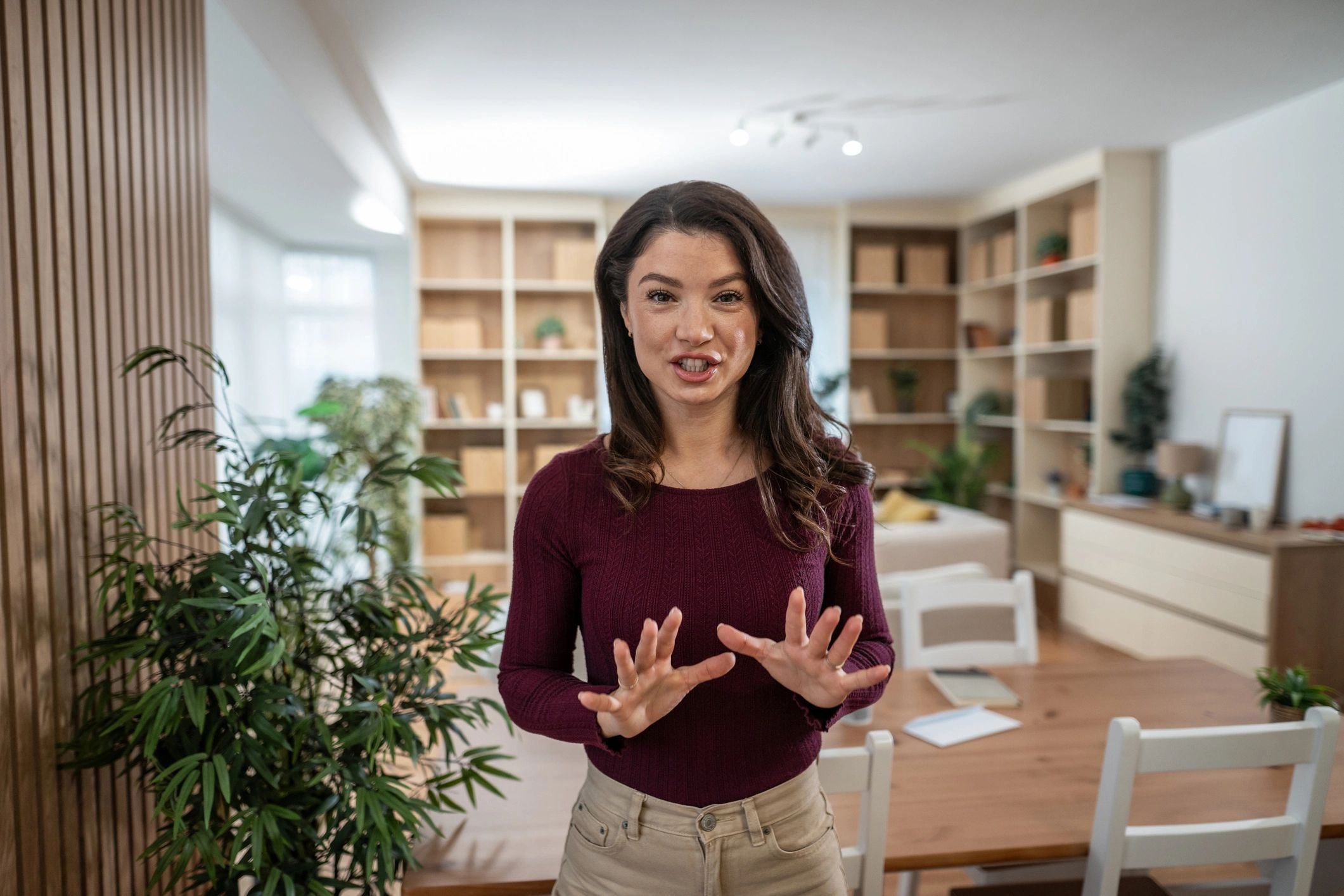 Woman speaking directly to camera in a modern workspace